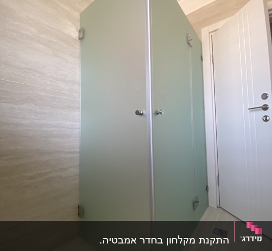 תא מקלחת עם דלת זכוכית ירוקה וידיות מתכת